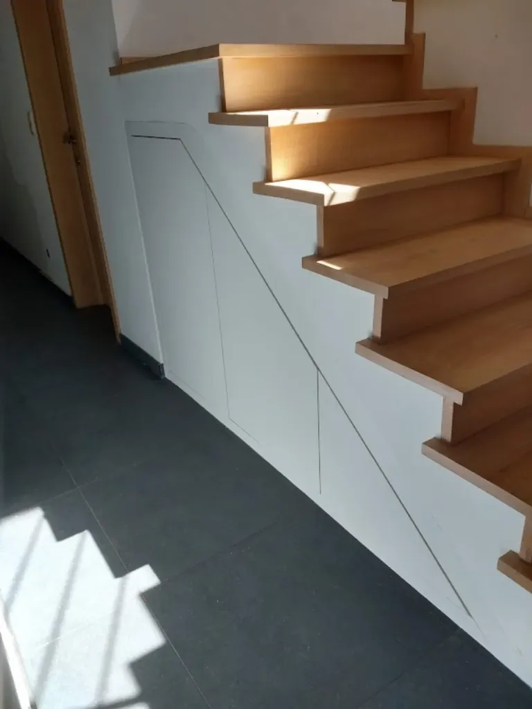 Greeploze kast onder een trap met eiken treden