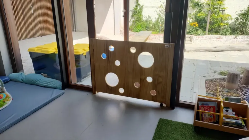 Houten hekje met ronde openingen in een kinderopvang